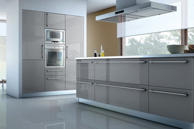Example of a mid-sized minimalist u-shaped porcelain tile eat-in kitchen design in Los Angeles with flat-panel cabinets, a double-bowl sink, gray cabinets, solid surface countertops, white backsplash, stone tile backsplash, stainless steel appliances and an island