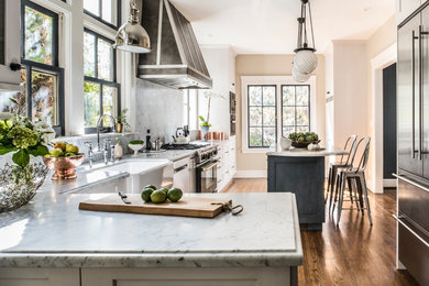 Inspiration for a large transitional l-shaped dark wood floor enclosed kitchen remodel in San Francisco with a farmhouse sink, white cabinets, stainless steel appliances, an island, shaker cabinets, marble countertops, multicolored backsplash and marble backsplash