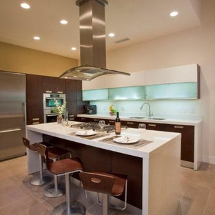 Zweizeilige, Große Moderne Küche mit Vorratsschrank, Doppelwaschbecken, flächenbündigen Schrankfronten, dunklen Holzschränken, Mineralwerkstoff-Arbeitsplatte, Küchenrückwand in Beige, Küchengeräten aus Edelstahl, Betonboden und Kücheninsel in Austin