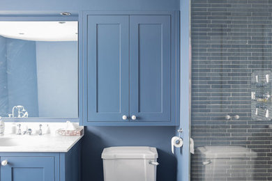 Design ideas for a large contemporary family bathroom in London with shaker cabinets, blue cabinets, a corner bath, a walk-in shower, a two-piece toilet, black tiles, slate tiles, blue walls, slate flooring, a submerged sink, marble worktops, grey floors, an open shower and white worktops.