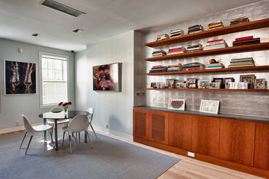 Mid-sized trendy light wood floor great room photo in New York with gray walls and no fireplace