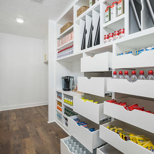 This is an example of a large traditional single-wall kitchen pantry in Houston with an undermount sink, raised-panel cabinets, white cabinets, marble benchtops, beige splashback, porcelain splashback, stainless steel appliances, laminate floors, with island, brown floor and white benchtop.