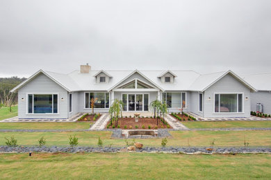 Imagen de fachada de casa gris y blanca de estilo de casa de campo grande de una planta con revestimiento de madera y tejado de metal