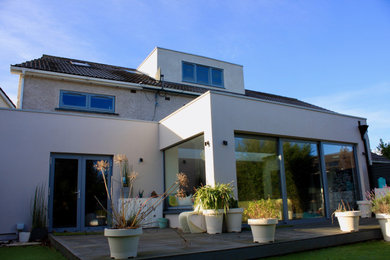 Modelo de fachada de casa bifamiliar beige actual de tres plantas con revestimiento de ladrillo y tejado a dos aguas