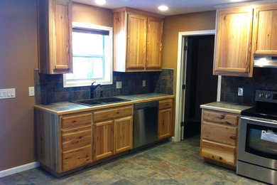 Eat-in kitchen - mid-sized rustic u-shaped laminate floor and multicolored floor eat-in kitchen idea in Other with a drop-in sink, recessed-panel cabinets, light wood cabinets, tile countertops, multicolored backsplash, stone tile backsplash, stainless steel appliances, no island and multicolored countertops