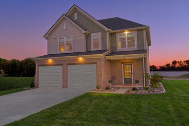 Large modern green two-story mixed siding and board and batten house exterior idea in Louisville with a hip roof, a shingle roof and a gray roof