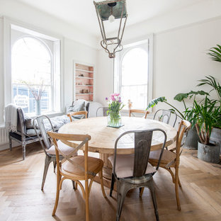 Design ideas for a mid-sized traditional open plan dining in Other with grey walls, medium hardwood floors, a standard fireplace, a wood fireplace surround and brown floor.