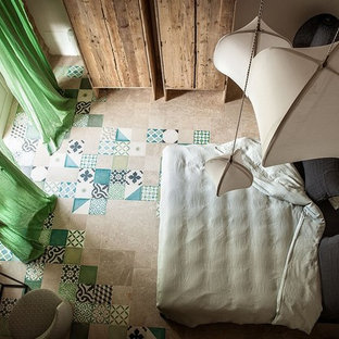 This is an example of a mid-sized mediterranean guest bedroom in Catania-Palermo with white walls, ceramic floors and multi-coloured floor.