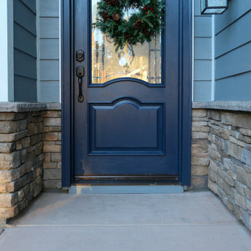 Home Exterior with Stacked Stone Veneer and Blue Front Door