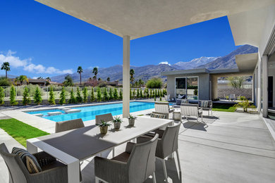 Inspiration for a large contemporary courtyard concrete patio remodel in Other with a roof extension