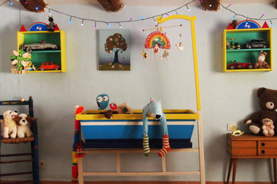 Exemple d'une chambre d'enfant de 1 à 3 ans rétro de taille moyenne avec un mur bleu, parquet clair, un sol marron et poutres apparentes.
