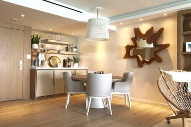 Mid-sized modern single-wall home bar in Miami with no sink, flat-panel cabinets, beige cabinets, marble benchtops, mirror splashback, light hardwood floors and beige floor.