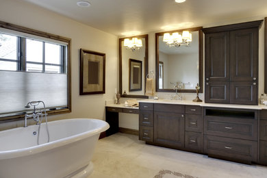 Large transitional master bathroom in Philadelphia with raised-panel cabinets, dark wood cabinets, a freestanding tub, beige walls, travertine floors, an undermount sink, marble benchtops and beige floor.