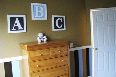 Small modern nursery in Denver with beige walls and carpet for boys.