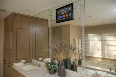 Photo of a large beach style master bathroom in Chicago with flat-panel cabinets, medium wood cabinets, an undermount tub, beige walls and an undermount sink.