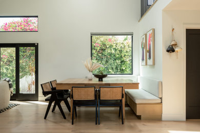 Ejemplo de comedor moderno pequeño sin chimenea con con oficina, paredes blancas, suelo de madera clara y suelo beige