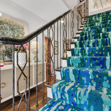Vibrant Staircase with Bold Blue Runner and Artistic Décor