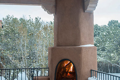Inspiration for a large southwestern backyard stone patio remodel in Albuquerque with a fire pit and a roof extension
