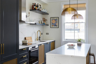 This is an example of a medium sized traditional single-wall enclosed kitchen in London with a single-bowl sink, shaker cabinets, blue cabinets, quartz worktops, white splashback, engineered quartz splashback, stainless steel appliances, dark hardwood flooring, an island, brown floors, white worktops and feature lighting.