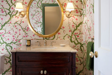 Mid-sized elegant medium tone wood floor powder room photo in Boston with recessed-panel cabinets, dark wood cabinets, multicolored walls, an undermount sink and quartz countertops