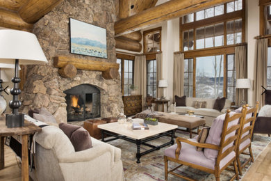 Inspiration for a mid-sized rustic open concept light wood floor and beige floor living room remodel in Denver with beige walls, a standard fireplace and a stone fireplace