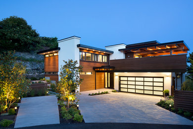 Inspiration for a large contemporary two-storey white exterior in Vancouver with a flat roof and mixed siding.