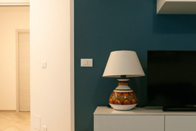 他の地域にある高級な中くらいなコンテンポラリースタイルのおしゃれなLDK (青い壁、磁器タイルの床、壁掛け型テレビ、茶色い床) の写真