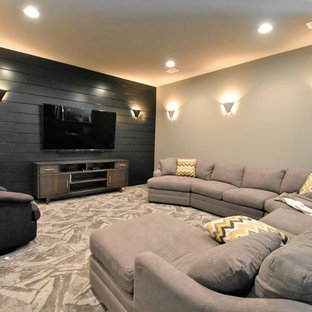 Example of a large trendy open concept carpeted and gray floor home theater design in Kansas City with black walls and a wall-mounted tv