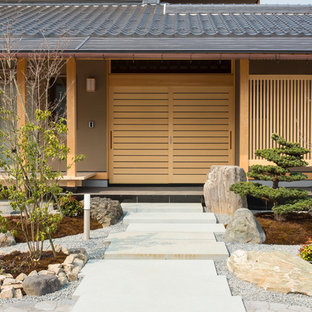 他の地域の引き戸アジアンスタイルのおしゃれな玄関ドア (茶色い壁、淡色木目調のドア) の写真