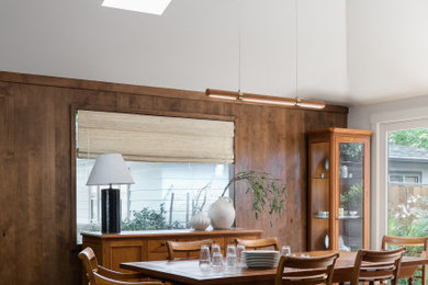 Example of a 1950s dark wood floor, brown floor and vaulted ceiling kitchen/dining room combo design in Denver with brown walls