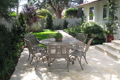Photo of a large traditional backyard patio in Other with natural stone pavers and no cover.