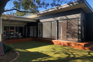 Small contemporary one-storey black house exterior in Adelaide with mixed siding, a shed roof and a metal roof.
