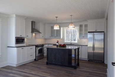 Mid-sized transitional l-shaped vinyl floor and orange floor eat-in kitchen photo in Other with an undermount sink, shaker cabinets, yellow cabinets, granite countertops, white backsplash, subway tile backsplash, stainless steel appliances and an island
