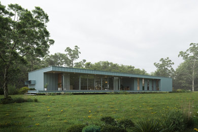 Modelo de fachada de casa gris y gris contemporánea de tamaño medio con revestimiento de metal, tejado plano y tejado de metal