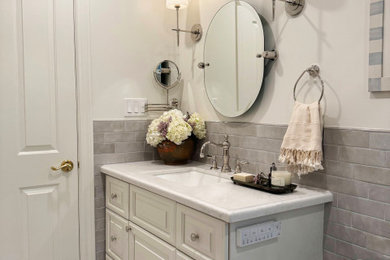 Mid-sized transitional 3/4 gray tile and ceramic tile single-sink bathroom photo in Los Angeles with raised-panel cabinets, white cabinets, an undermount sink, marble countertops and white countertops