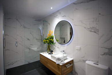 Contemporary bathroom in Brisbane with multi-coloured tile, porcelain tile and an open shower.