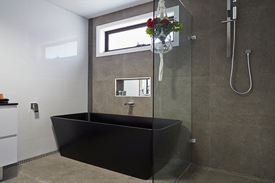 Inspiration for a large modern master bathroom in Sydney with a vessel sink, furniture-like cabinets, white cabinets, a freestanding tub, a corner shower, a one-piece toilet, white tile, ceramic tile, white walls and ceramic floors.