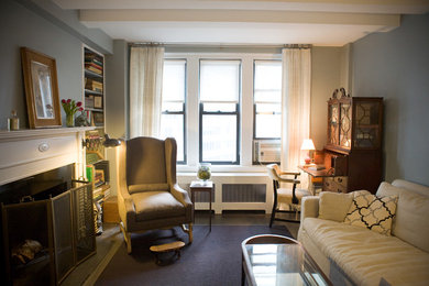 Inspiration for a large transitional enclosed dark wood floor living room library remodel in New York with gray walls, a standard fireplace and a wood fireplace surround