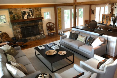 Inspiration for a large contemporary open concept medium tone wood floor and brown floor family room remodel in New York with gray walls, a standard fireplace, a stone fireplace and no tv