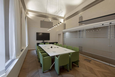 Foto di un ampio ufficio minimalista con pareti bianche, parquet chiaro e soffitto a volta