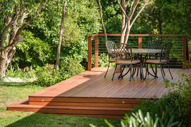Photo of a mid-sized traditional backyard and ground level deck in Canberra - Queanbeyan with no cover and cable railing.