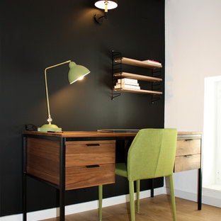 Inspiration for a small modern study in Barcelona with black walls, medium hardwood flooring, a freestanding desk and brown floors.