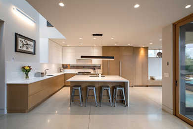 Inspiration for a large scandinavian l-shaped white floor eat-in kitchen remodel in Vancouver with an undermount sink, flat-panel cabinets, medium tone wood cabinets, white backsplash, an island and white countertops