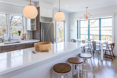 Inspiration for a large contemporary l-shaped light wood floor open concept kitchen remodel in New York with flat-panel cabinets, quartz countertops, gray backsplash, mosaic tile backsplash, stainless steel appliances, an island and dark wood cabinets