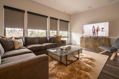 Design ideas for a mid-sized modern enclosed family room in Seattle with beige walls, dark hardwood floors, a wall-mounted tv and brown floor.