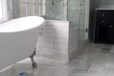 Example of a mid-sized minimalist master gray tile, white tile and porcelain tile marble floor bathroom design in Atlanta with shaker cabinets, black cabinets, a one-piece toilet, gray walls, an undermount sink and solid surface countertops