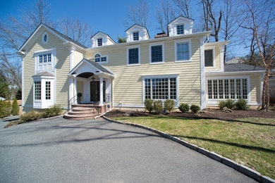 Large elegant beige three-story concrete fiberboard gable roof photo in New York