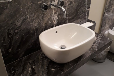 Foto di una piccola stanza da bagno industriale con nessun'anta, doccia alcova, WC a due pezzi, piastrelle grigie, piastrelle di marmo, pareti beige, pavimento in marmo, lavabo a bacinella, top in marmo, pavimento grigio, porta doccia a battente e top grigio