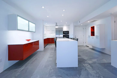 Open concept kitchen - large modern l-shaped open concept kitchen idea in Tampa with an undermount sink, flat-panel cabinets, white cabinets, quartzite countertops, gray backsplash, stainless steel appliances and an island