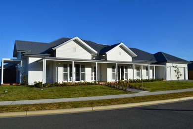 Design ideas for a large country one-storey white house exterior in Wollongong with mixed siding, a hip roof and a metal roof.